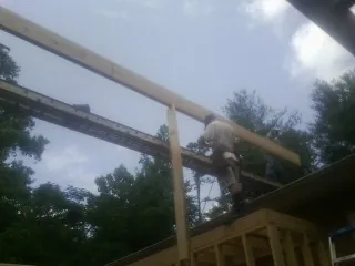 Carpenter setting a ridge beam over a new addition frame — Ice Dam Removal by Roofing Brothers in New Berlin