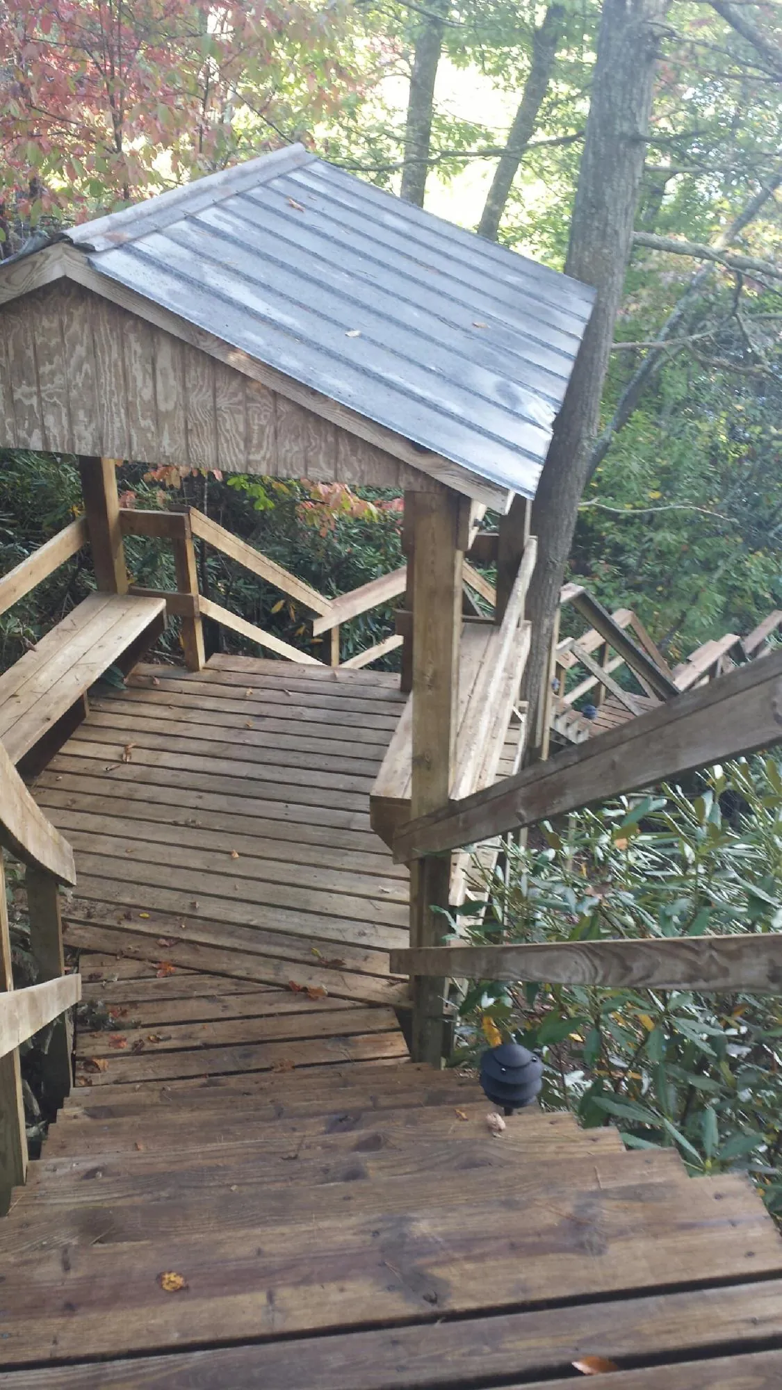 Metal roofed shelter over wooden steps on a wooded walkway — Skylight Repair & Installation work by our crew in New Berlin